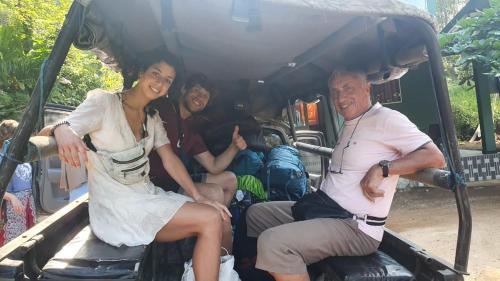 a group of people sitting in the back of a golf cart at Sinharaja Hostel in Deniyaya