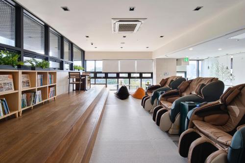 a large room with couches and bookshelves at The Island Blue Hotel in Seogwipo