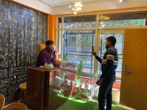 two men standing at a bar in a room at MAMTA HOMESTAY in Darjeeling