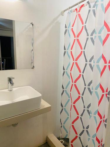 a bathroom with a sink and a shower curtain at Kite Room in Rodrigues Island