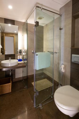 a bathroom with a shower and a toilet and a sink at Fortune Resort Grace, Mussoorie - Member ITC Hotels' Group in Mussoorie
