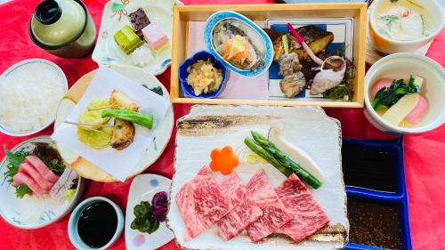 a table topped with plates of food and bowls of food at Route Inn Grantia Aoshima Taiyokaku in Miyazaki