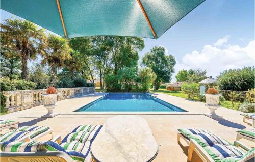 a swimming pool with chairs and an umbrella at Cozy Home In Saint-vivien-de-medoc With Wifi in Saint-Vivien-de-Médoc