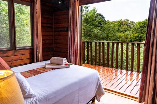 a bedroom with a bed on a porch at Mtunzini Forest Lodge Self Catering Resort in Mtunzini