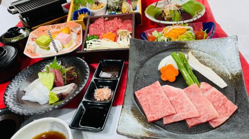 a table with plates of food and bowls of food at Route Inn Grantia Aoshima Taiyokaku in Miyazaki