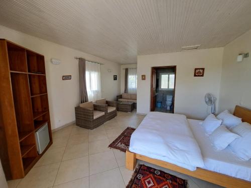 a bedroom with a large bed and a living room at Aux 2 Métis in Toliara