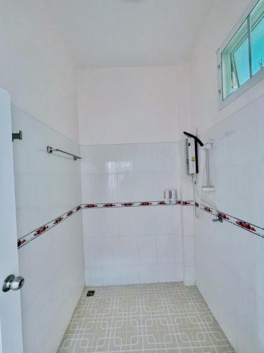 a white bathroom with a shower and a window at Phuyafahsai The Resort Khao Kho in Khao Kho