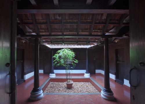 a potted plant in a room with a ceiling at Green Meadows Resort in Chennai