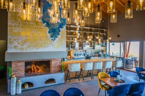 a bar with a fireplace and chairs and chandeliers at Pensiunea Casa Buna in Gîrbova