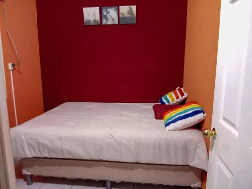 a bed with two pillows on it in a room at Jasper House en Ciudad Real Santa Ana in Santa Ana
