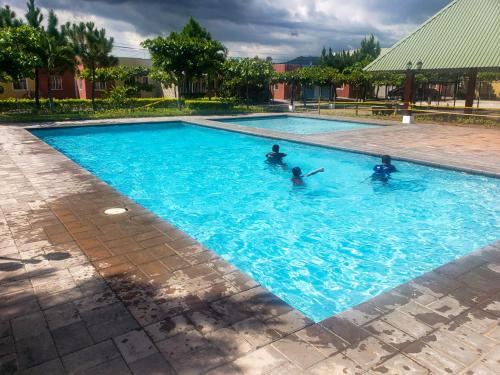a group of people swimming in a swimming pool at Jasper House en Ciudad Real Santa Ana in Santa Ana