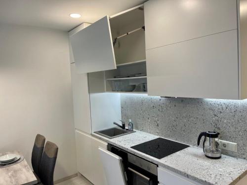 a kitchen with white cabinets and a counter top at Central apartment in Vilnius