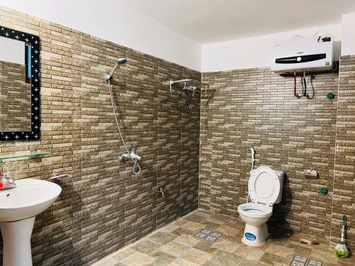 a bathroom with a shower and a toilet and a sink at Homestay Bản Giốc- Tay's Traditional Village in Cao Bằng