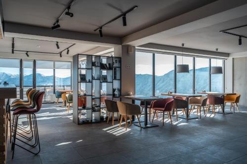 a dining room with tables and chairs and windows at Gogi Resort in Gudauri