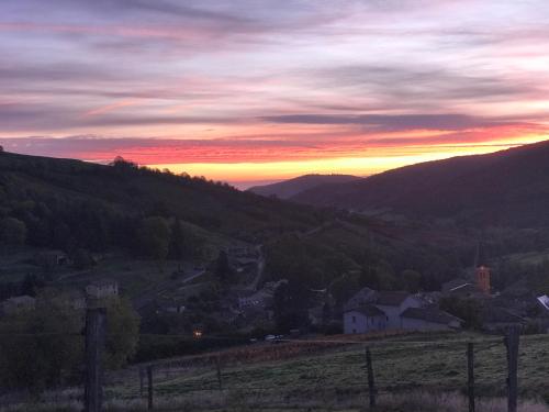 a sunset over a small town in a valley at Ravissant appartement dans cadre verdoyant in Marchampt