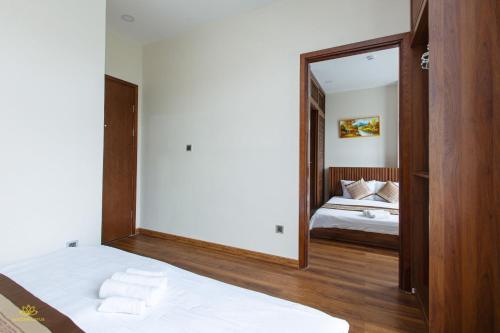 a mirror in a room with a bed and a bedroom at Golden Lotus Homestay Phú Quốc in Phu Quoc