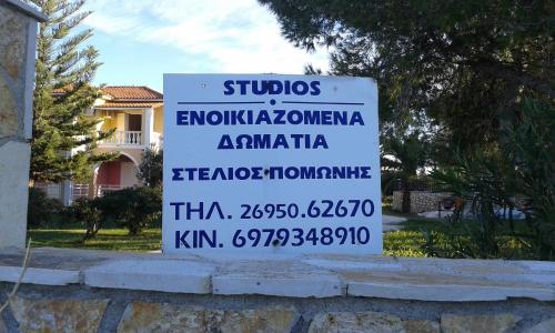 a sign on a wall in front of a building at Stelios Studios in Tragaki