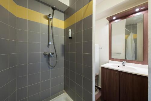 La salle de bains est pourvue d'une douche et d'un lavabo. dans l'établissement Garden & City Toulon, à Toulon