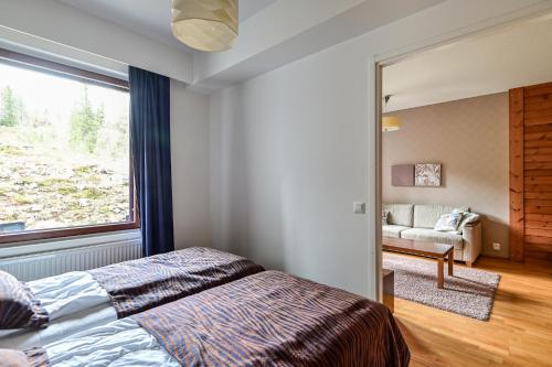 1 dormitorio con cama y ventana grande en Ylläs Saaga Ski Chalets 2 en Ylläsjärvi