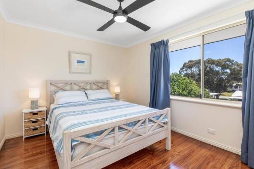 een slaapkamer met een bed en een groot raam bij Light & bright Falcon Bay family holiday escape in Mandurah