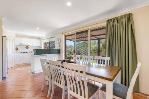a kitchen and dining room with a table and chairs at Light & bright Falcon Bay family holiday escape in Mandurah