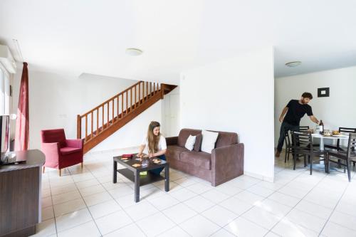 a man and a woman sitting in a living room at Garden & City Lyon - Marcy in Marcy-lʼÉtoile