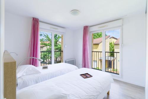 two beds in a room with two windows at Garden & City Lyon - Marcy in Marcy-lʼÉtoile