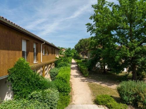 a path next to a building with trees at Garden & City Lyon - Marcy in Marcy-lʼÉtoile
