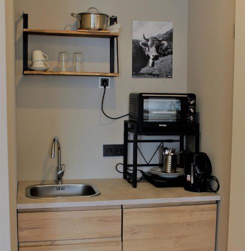 a kitchen with a sink and a television on a counter at ARRIVEL Apartements Heimstetten - bisher Novitel in Kirchheim