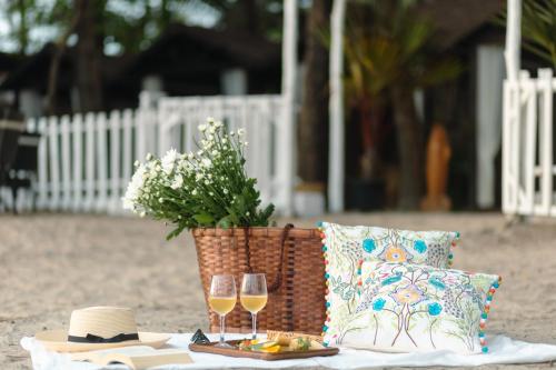 a picnic table with two glasses of wine and a basket at Larisa Beach Resort in Morjim