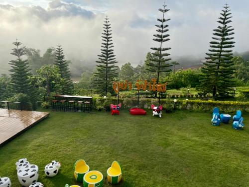a backyard with a playground with toys on the grass at Phuyafahsai The Resort Khao Kho in Khao Kho