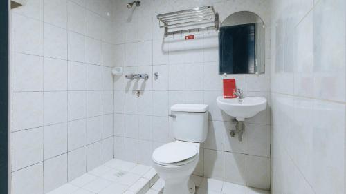 La salle de bains blanche est pourvue de toilettes et d'un lavabo. dans l'établissement RedDoorz @ Riches Holiday Hotel Avenida, à Manille