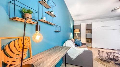 um quarto com uma parede azul com um banco e uma cadeira em HOMEY HELSINKI - Hyper centre - Proche Genève - Terrasse privée - Wifi & Netflix em Annemasse