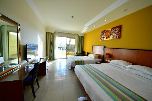 a hotel room with two beds and a desk at Xperience Kiroseiz AquaPark Premier-Naama Bay in Sharm El Sheikh