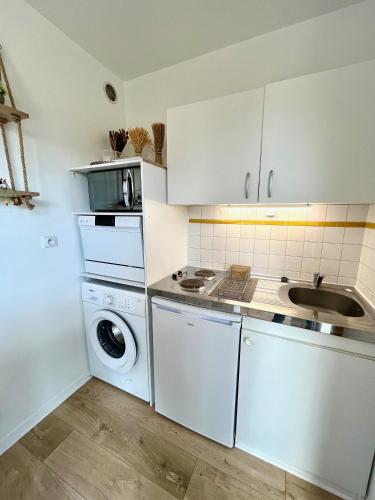a kitchen with a washing machine and a sink at Salm, Coquet studio avec balcon in Ouistreham