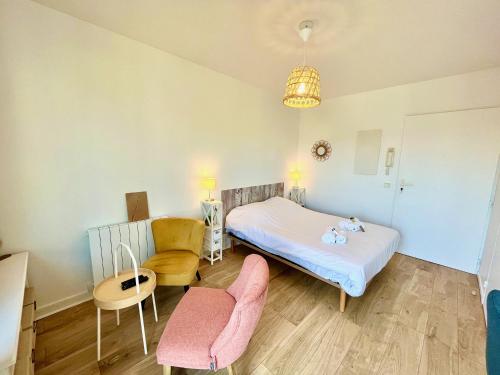 a small bedroom with a bed and a chair at Salm, Coquet studio avec balcon in Ouistreham