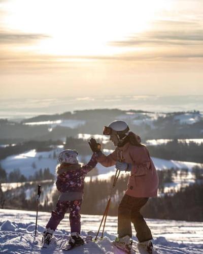 a woman and a child on skis in the snow at Apartmán Adam Deštné v Orlických horách in Deštné v Orlických horách
