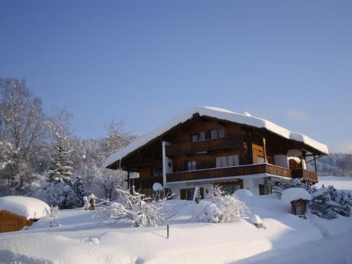 a large wooden house covered in snow at Gästehäuser Schwemmbauer in Reit im Winkl