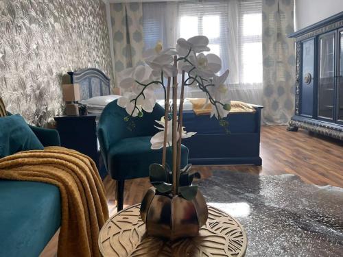 a living room with a vase with flowers on a table at Ferienwohnung Royal im Tilly Boardinghouse in Hannoversch Münden