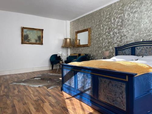 a bedroom with a large bed with a blue frame at Ferienwohnung Royal im Tilly Boardinghouse in Hannoversch Münden