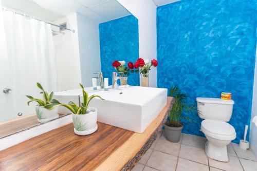 a bathroom with a white sink and a blue wall at Sand and Tan Beach Hotel in Ocho Rios