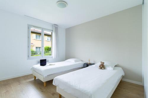 2 camas en una habitación blanca con ventana en Garden & City Lyon - Lissieu, en Lissieu