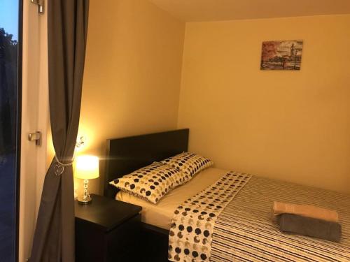 ein Schlafzimmer mit einem Bett mit einem Kissen und einer Lampe in der Unterkunft Studio-4 for professionals in Staines