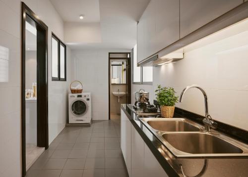 a kitchen with a sink and a washing machine at TRILLION SUITES by SLG in Kuala Lumpur