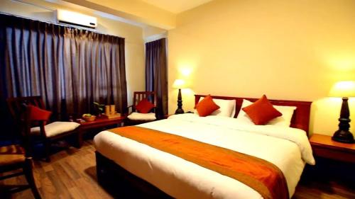 a hotel room with a large bed with red pillows at Hotel Golden Sunrise & Spa in Pelling