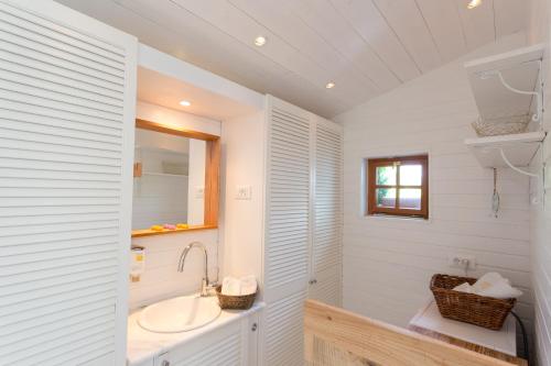 a white bathroom with a sink and a mirror at PAVI APARTMENTS Life Style House with private pool in Kornić