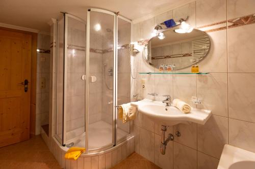y baño con ducha y lavamanos. en Alpengasthof Pichler, en Sankt Veit in Defereggen
