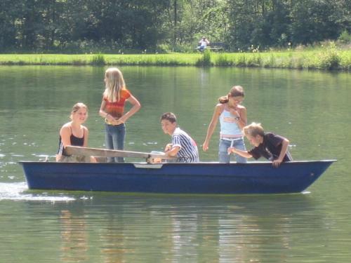 a group of children in a blue boat on the water at Ferien am Talhof in Sankt Urban