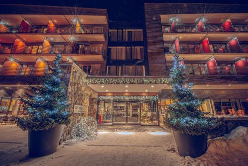 two christmas trees in front of a building at Wellness Hotel Vista in Dolní Morava