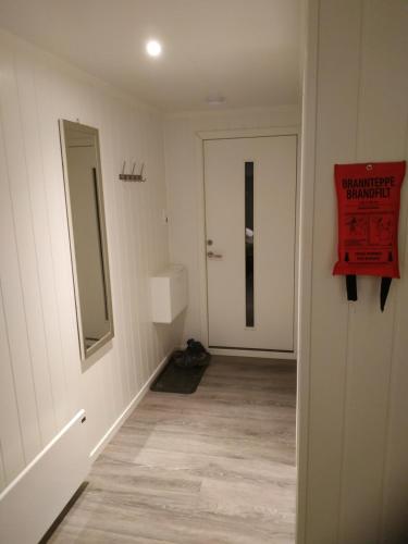 an empty hallway with a mirror and a door at Apartament 1 Havoysund in Havøysund